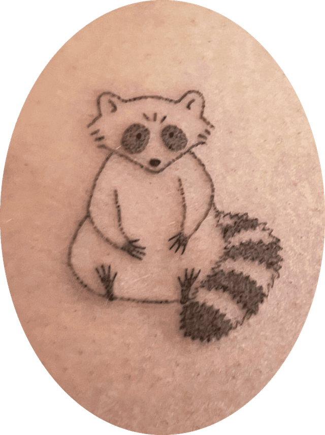 tattoo of a little raccoon sitting with shaded circle eyes and black and white striped tail